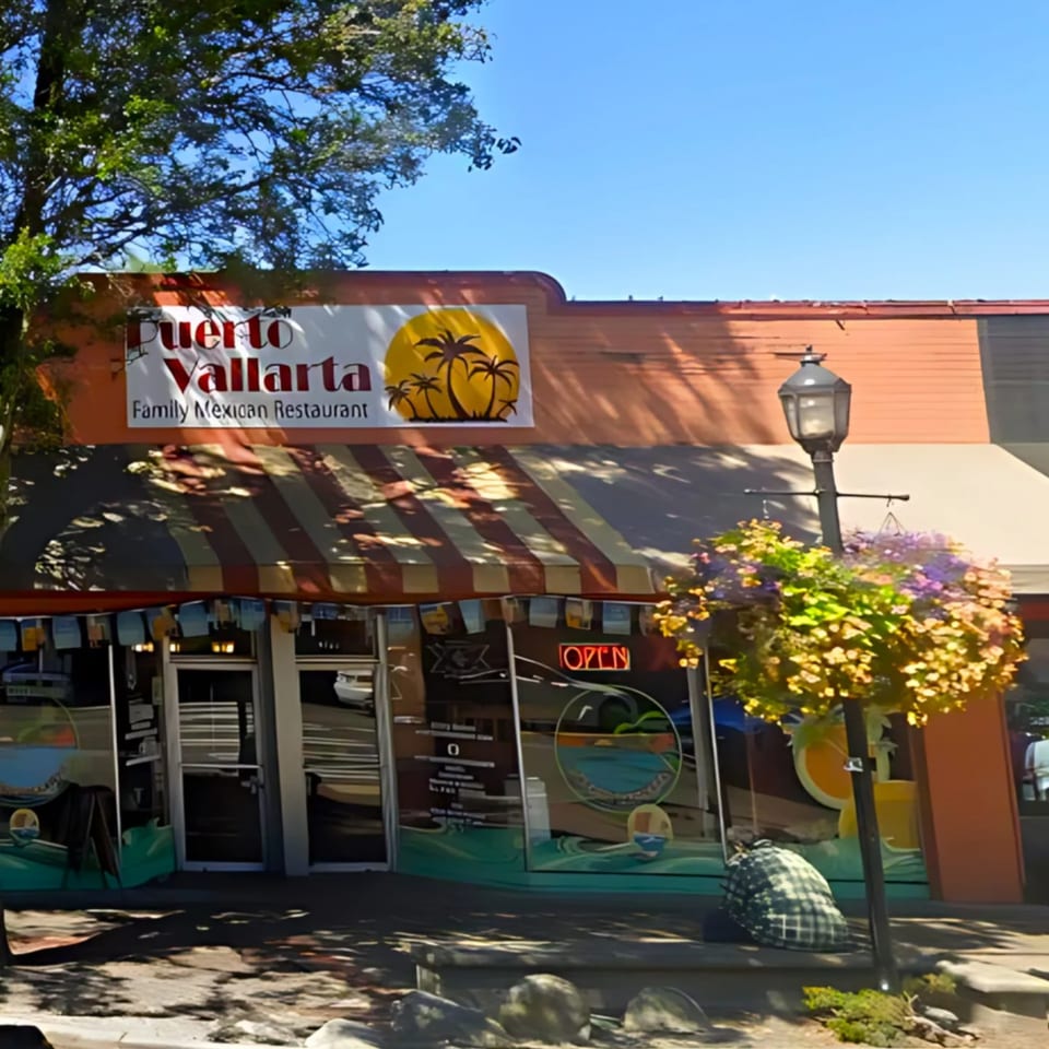 The exterior of Puerto Vallarta Family Mexican Restaurant with an "Open" sign in the window.